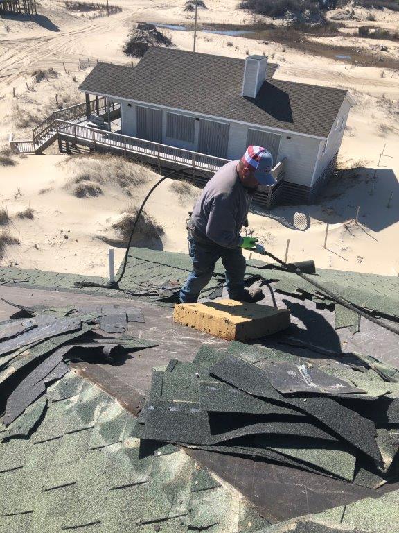 a man working on the roof of a house .