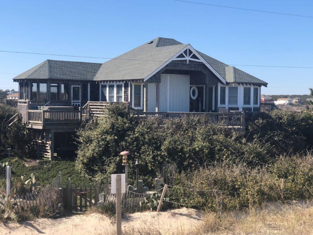 a large house sits on top of a hill surrounded by bushes