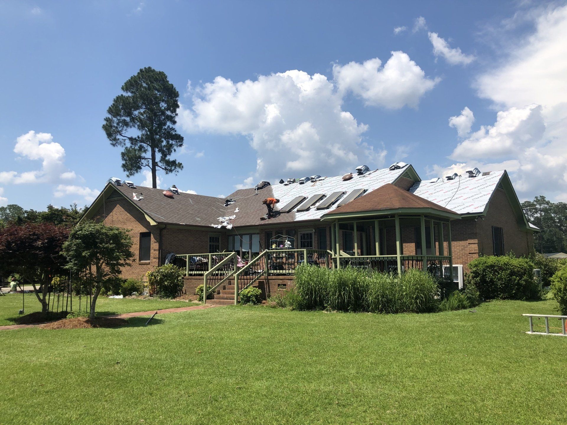 a large brick house with a roof that is being installed .