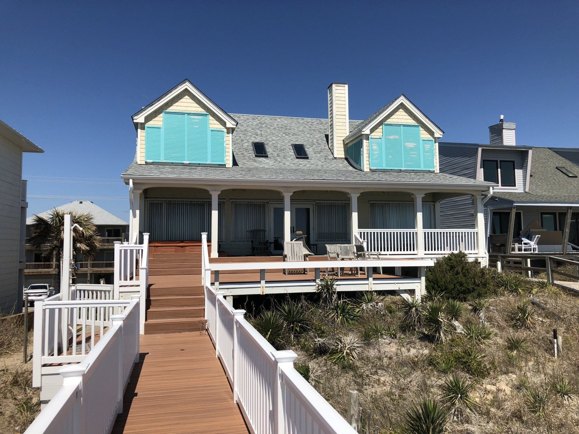 a large white house with a wooden walkway leading to it .