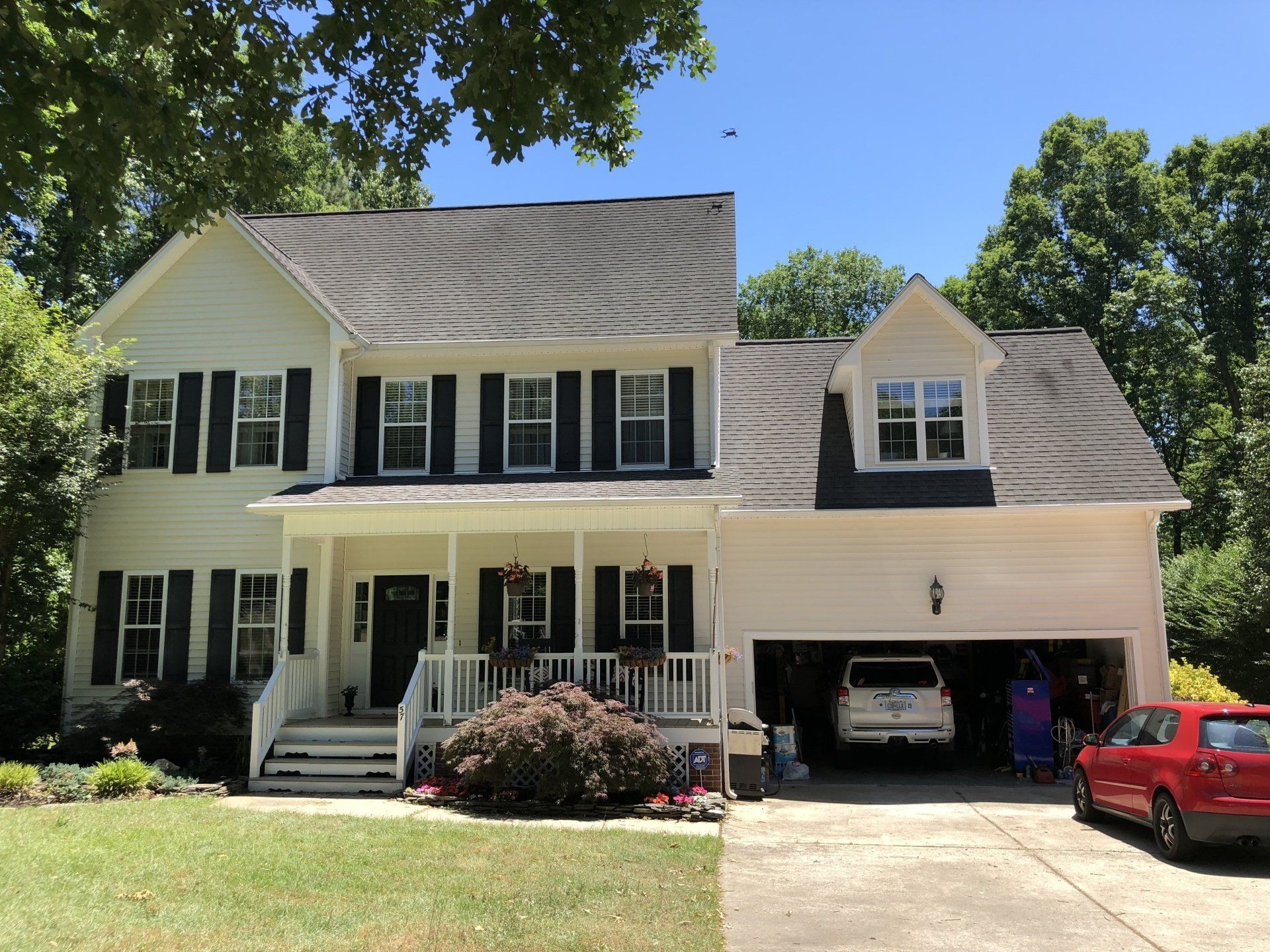 a large white house with a red car parked in front of it