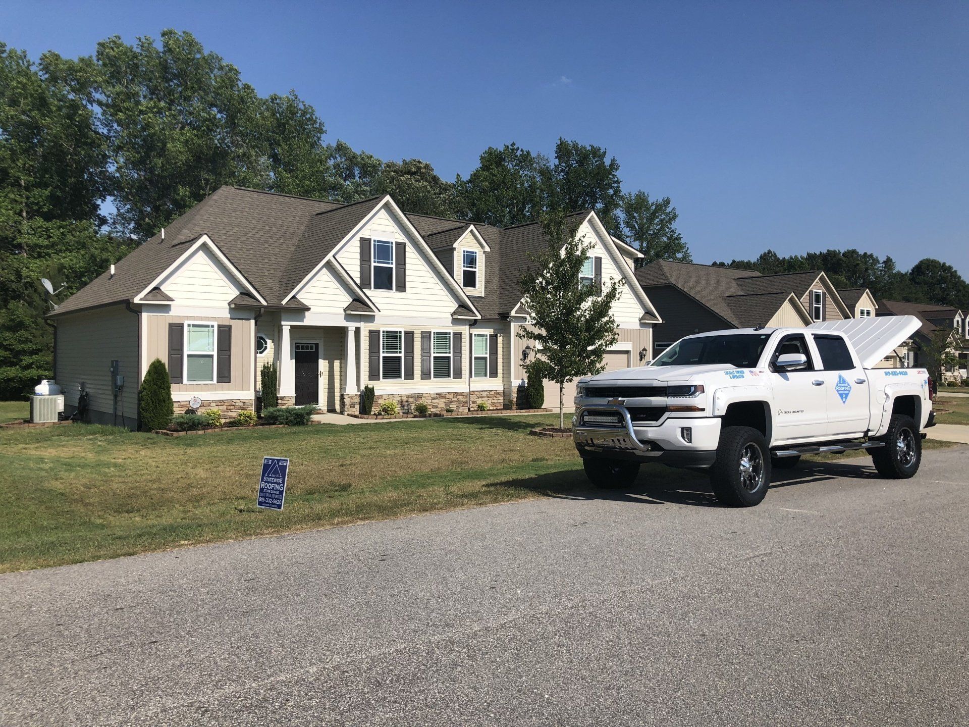 a white truck is parked in front of a house .