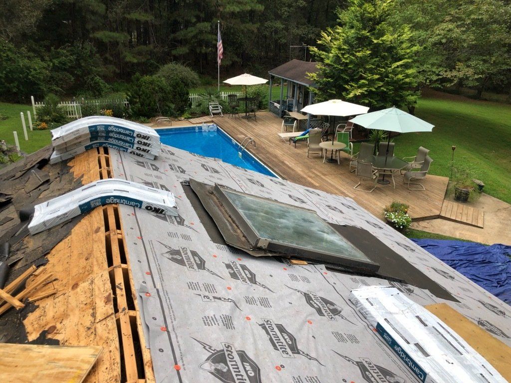 a roof with a skylight and a pool in the background .