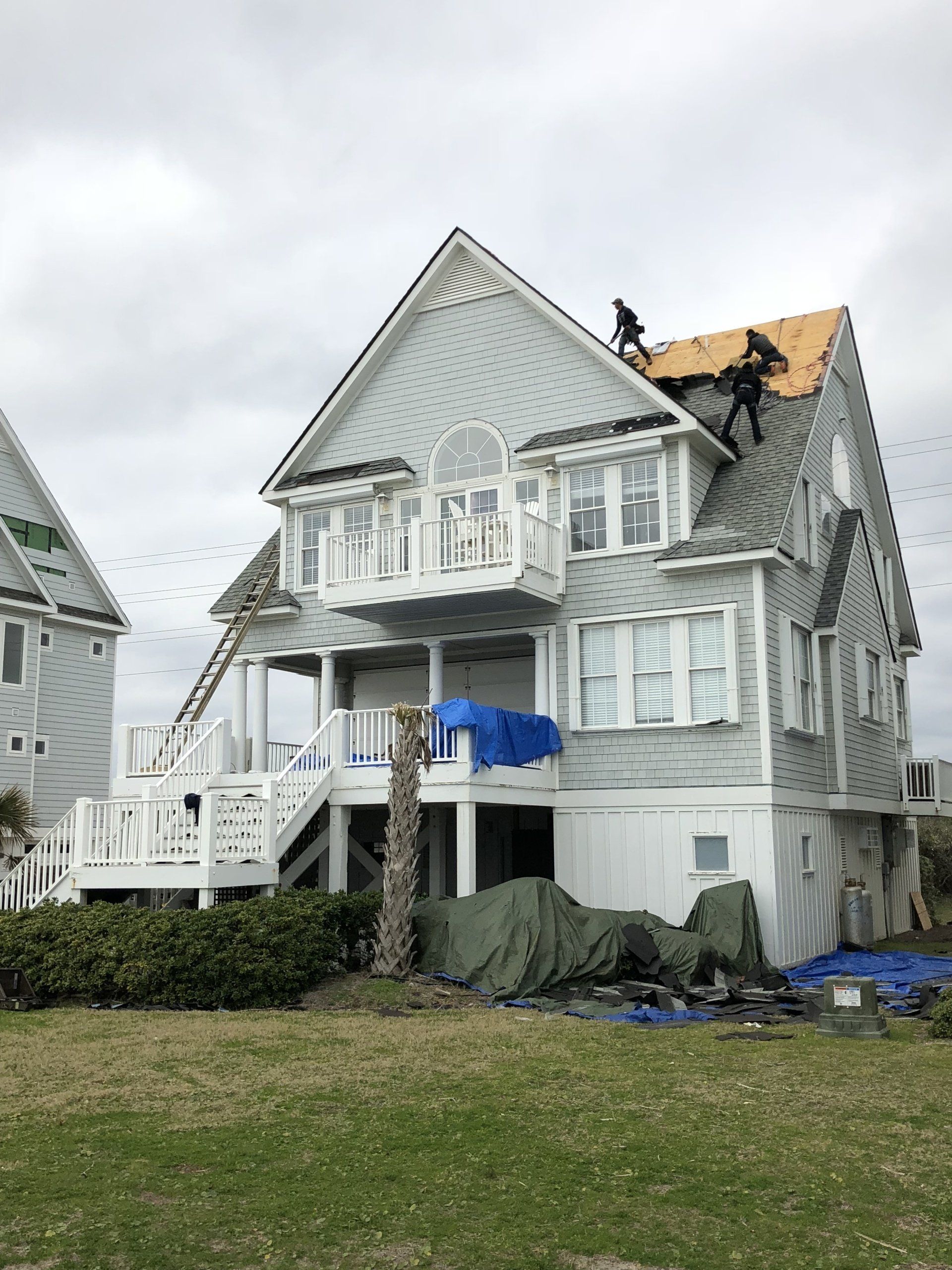 a large white house with a roof that is being repaired .