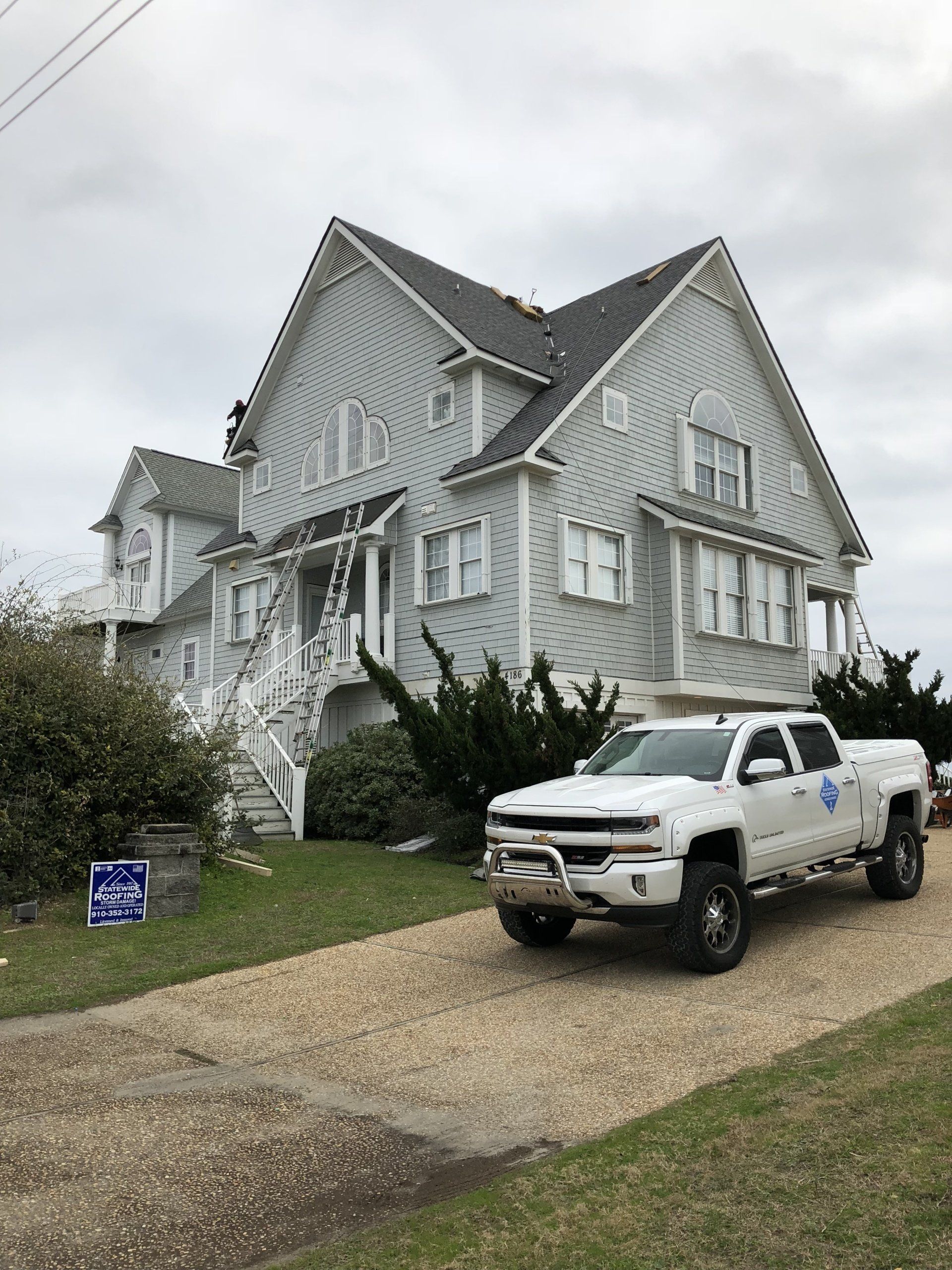 a white truck is parked in front of a large house .