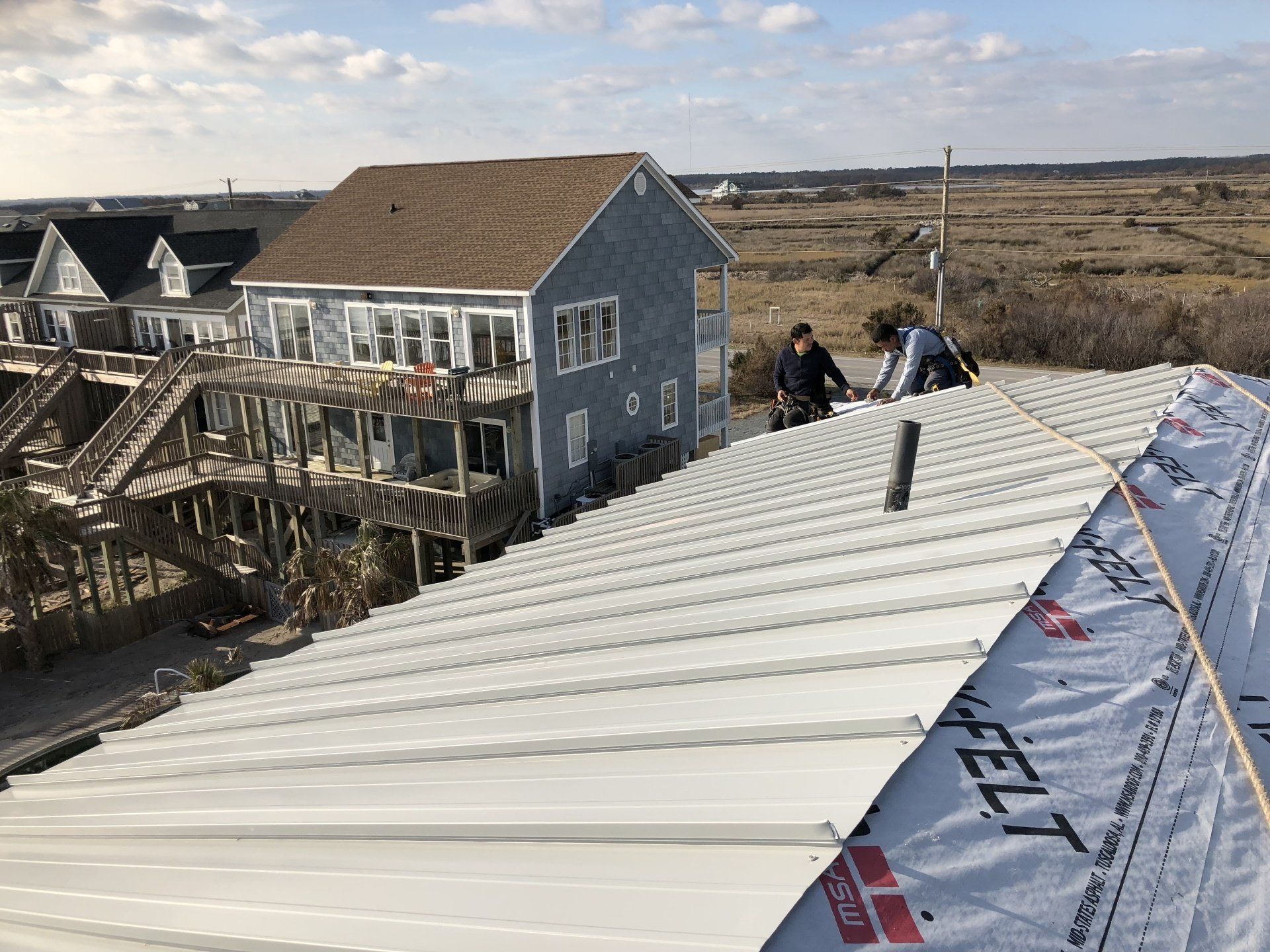 a group of people are working on the roof of a house .