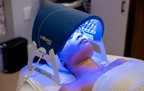 Person receiving blue light therapy treatment with a Colluma device.