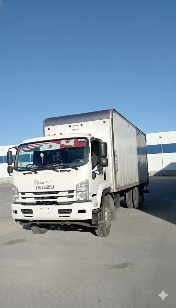 Camión Isuzu blanco estacionado frente a un edificio en un día soleado.