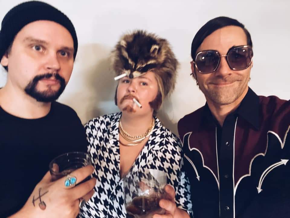 Two men and a woman are posing for a picture