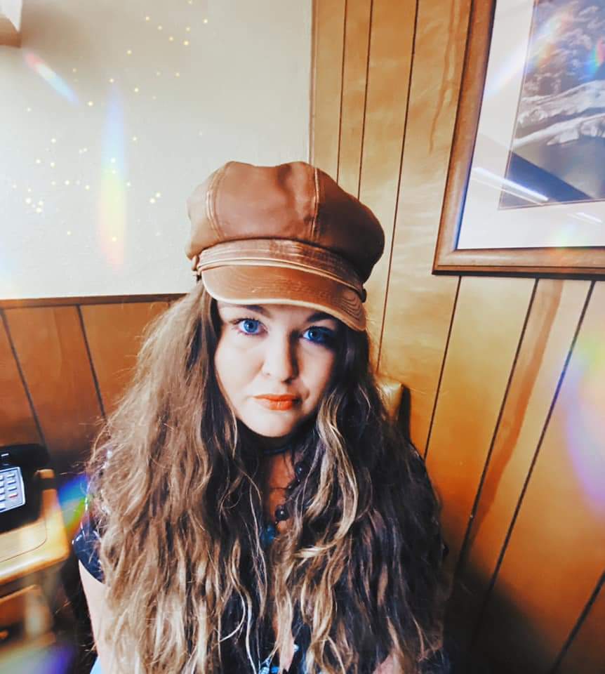 A woman wearing a hat is sitting in a chair