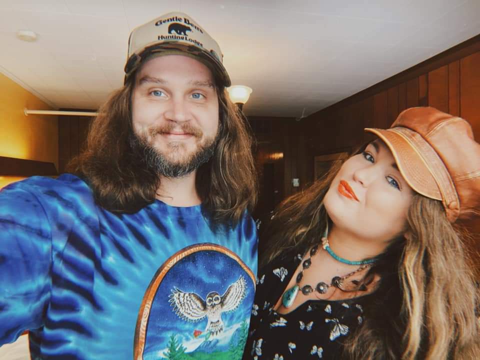 A man and a woman are posing for a picture in a room.