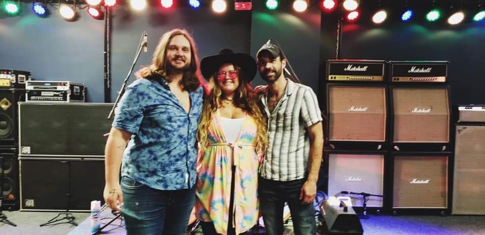 A group of people standing next to each other on a stage in front of a microphone.