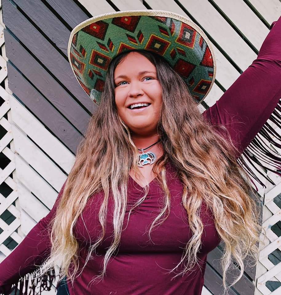 A woman wearing a cowboy hat and a purple shirt