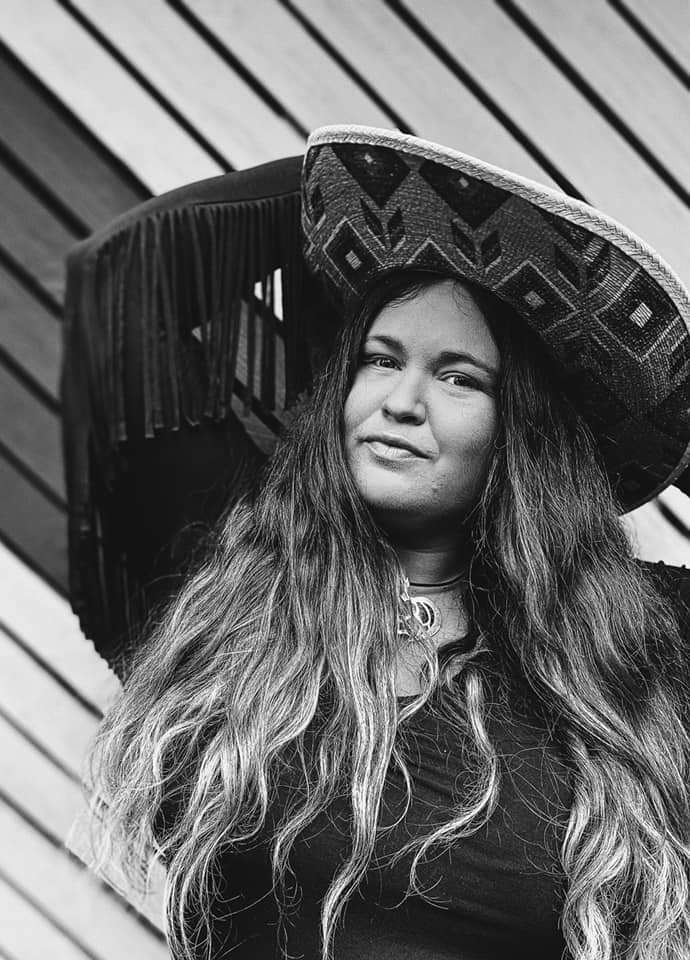 A black and white photo of a woman wearing a sombrero.