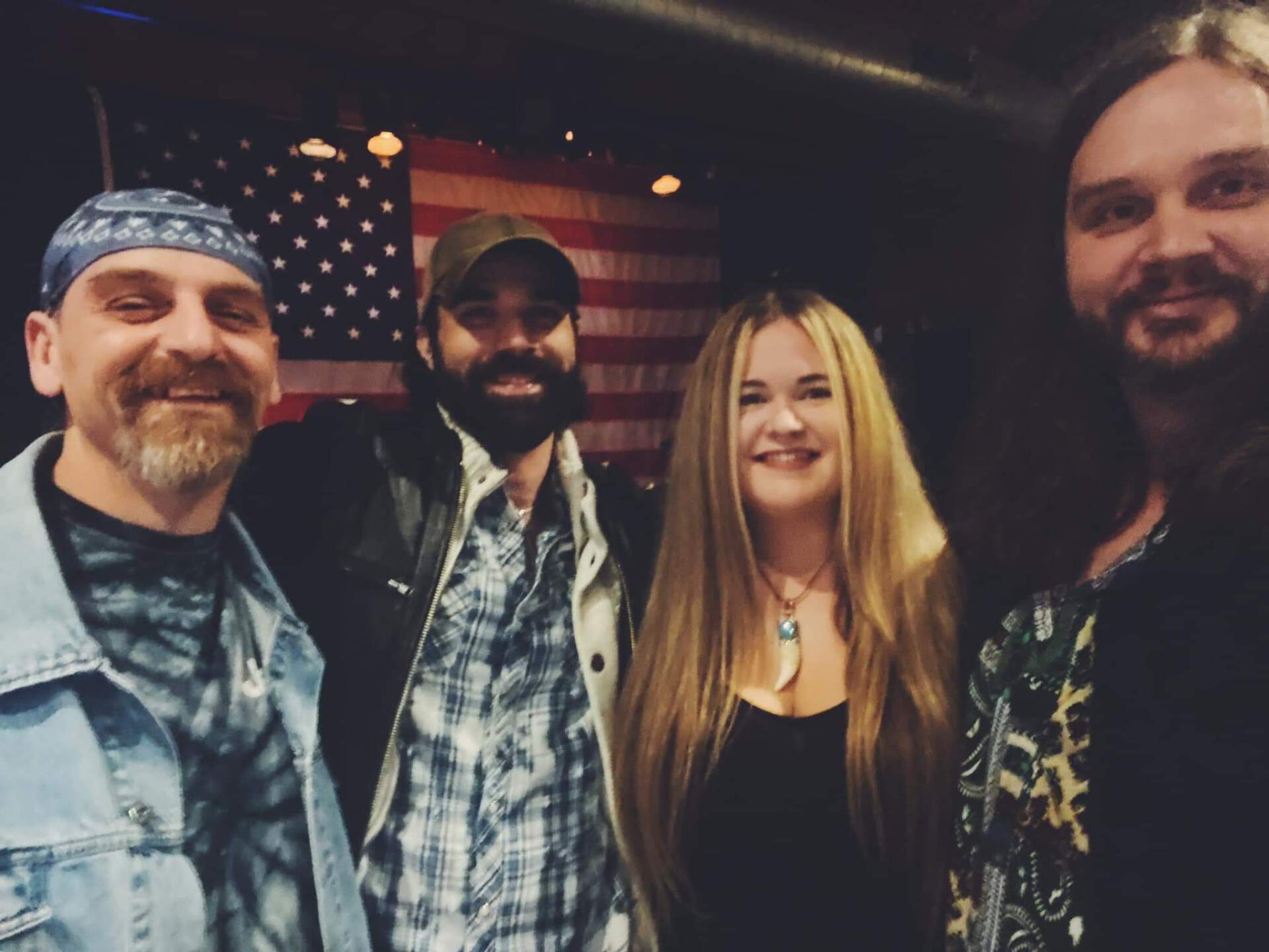 A group of people posing for a picture in front of an american flag