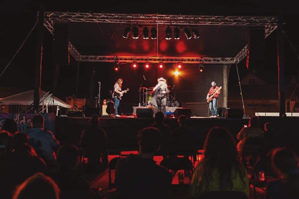A group of people are sitting in front of a stage at a concert.