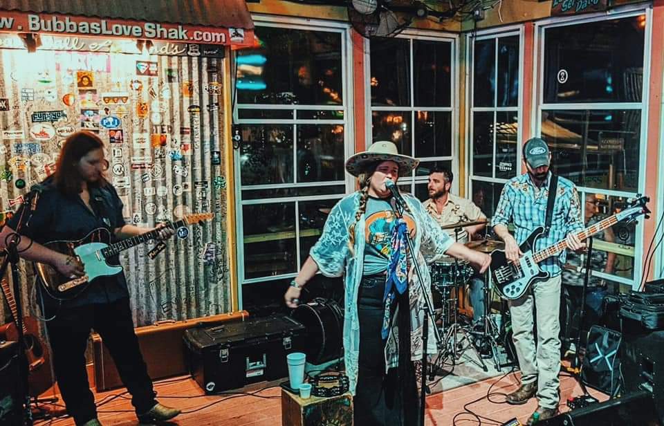 A group of men are playing guitars and singing into microphones on a stage.