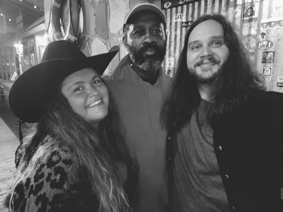 A black and white photo of three people posing for a picture.