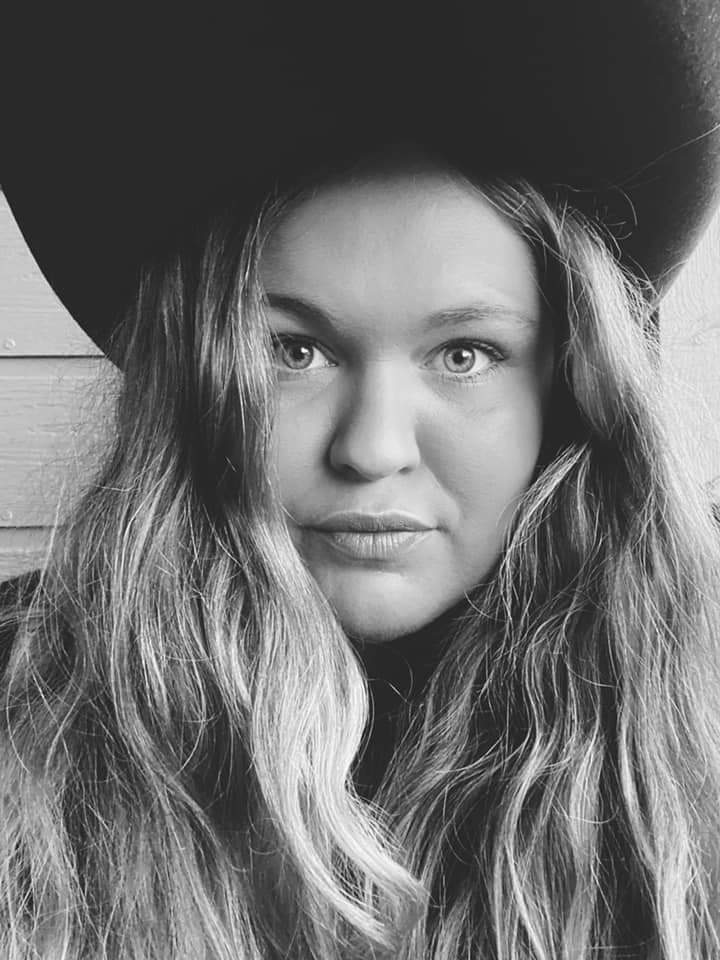A black and white photo of a woman wearing a hat.