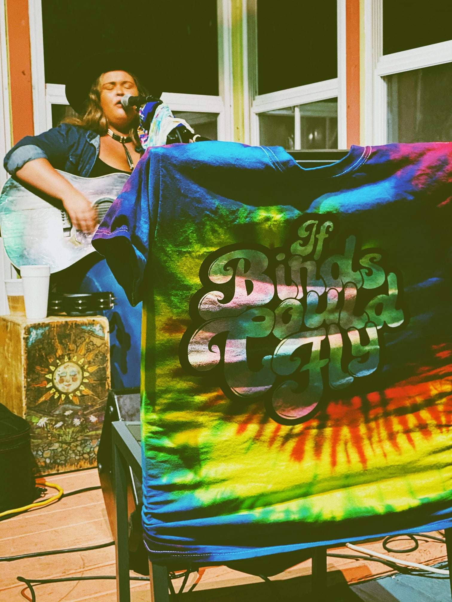 A woman is singing into a microphone while playing a guitar.