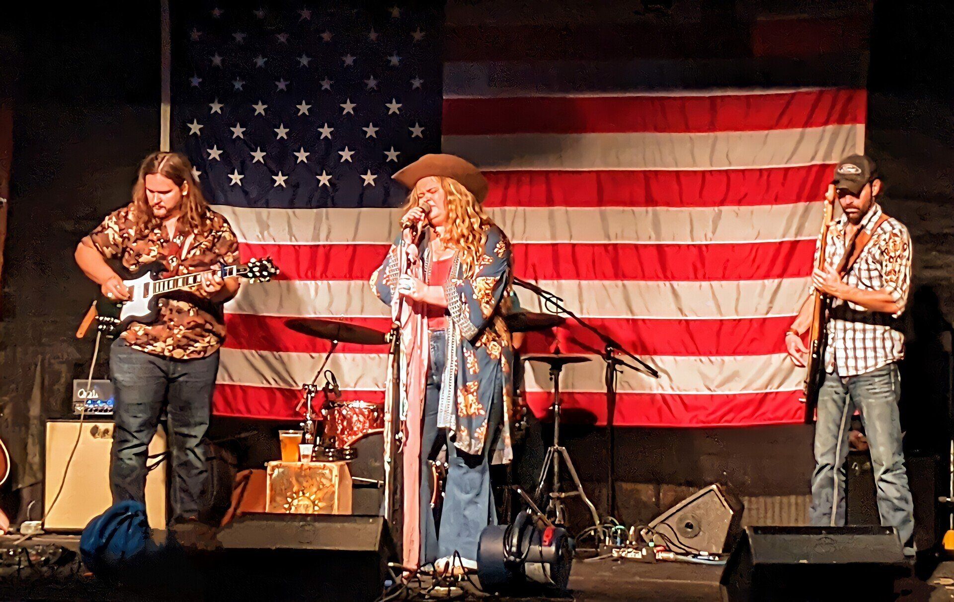 A group of people are playing instruments on a stage in front of an american flag.