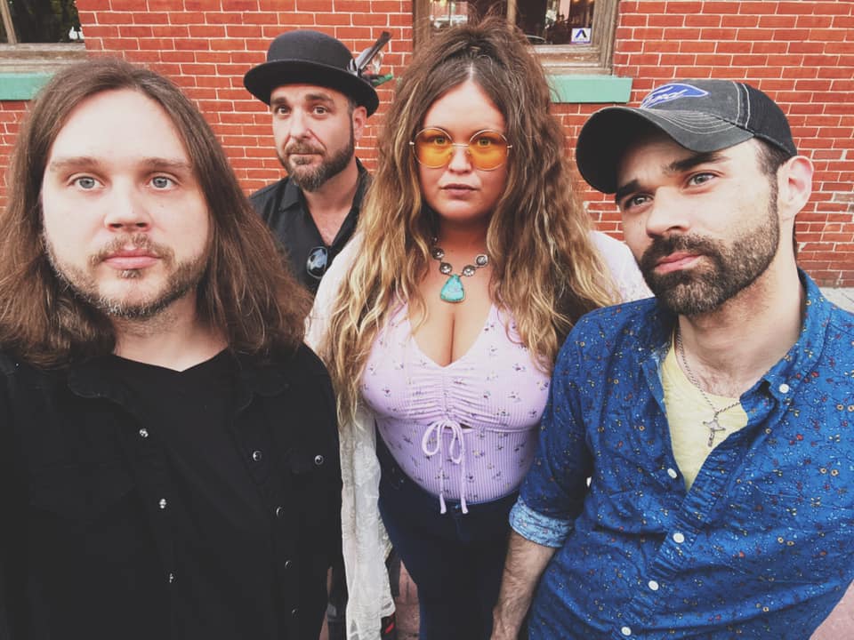 A group of people are posing for a picture in front of a brick building.