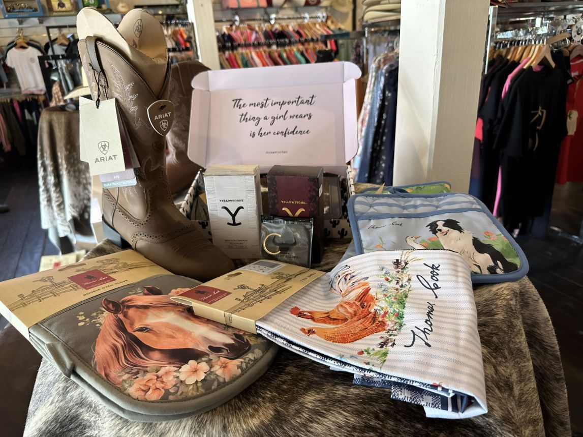 A Table With A Bunch Of Items On It Including A Pair Of Cowboy Boots — Shellie's Country Wear In Nabiac, NSW
