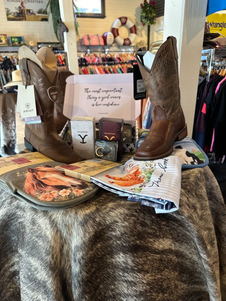 A Pair Of Cowboy Boots Are Sitting On Top Of A Table In A Store — Shellie's Country Wear In Forster, NSW