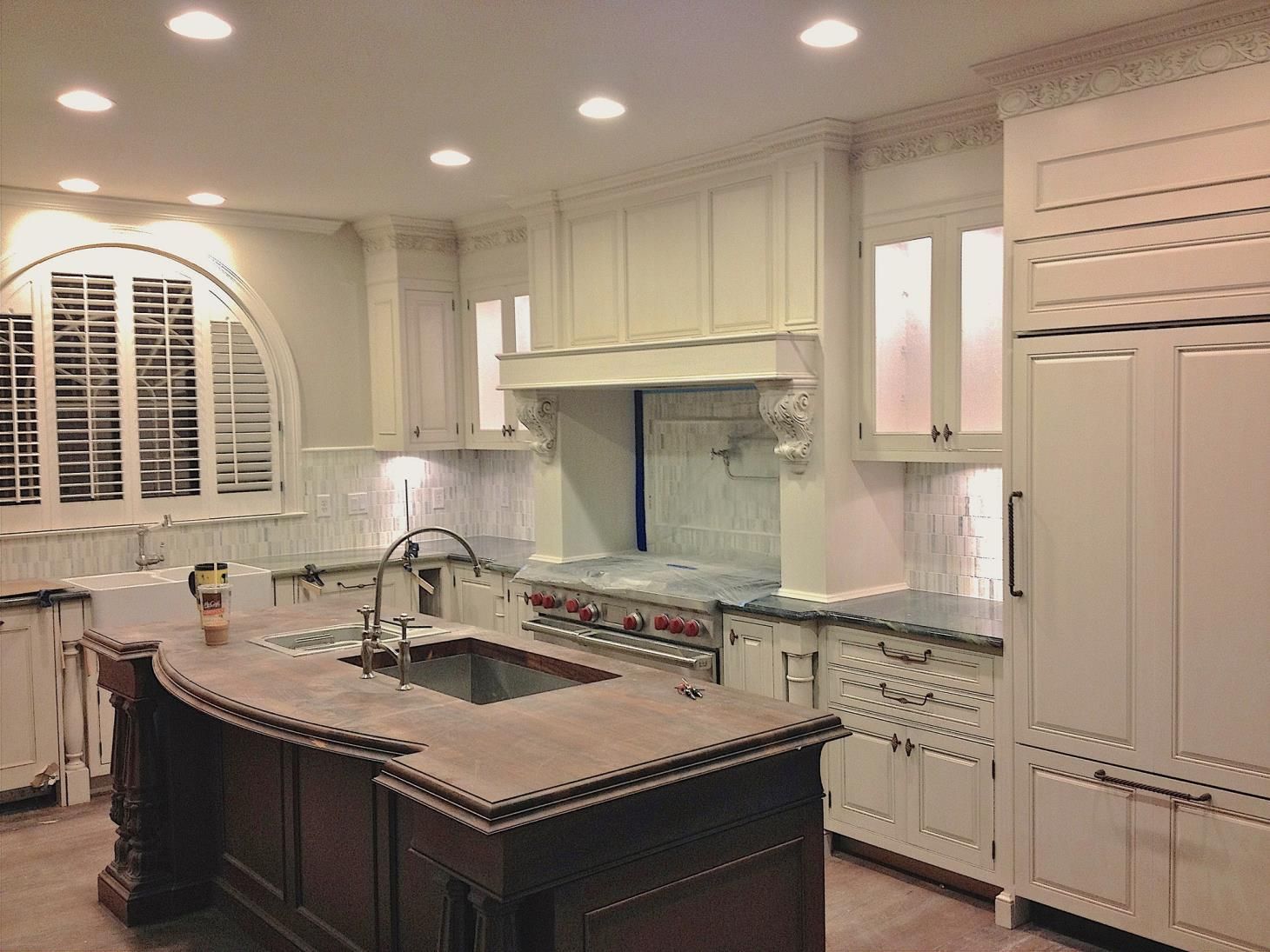 A room with a lot of white cabinets and a mirror.