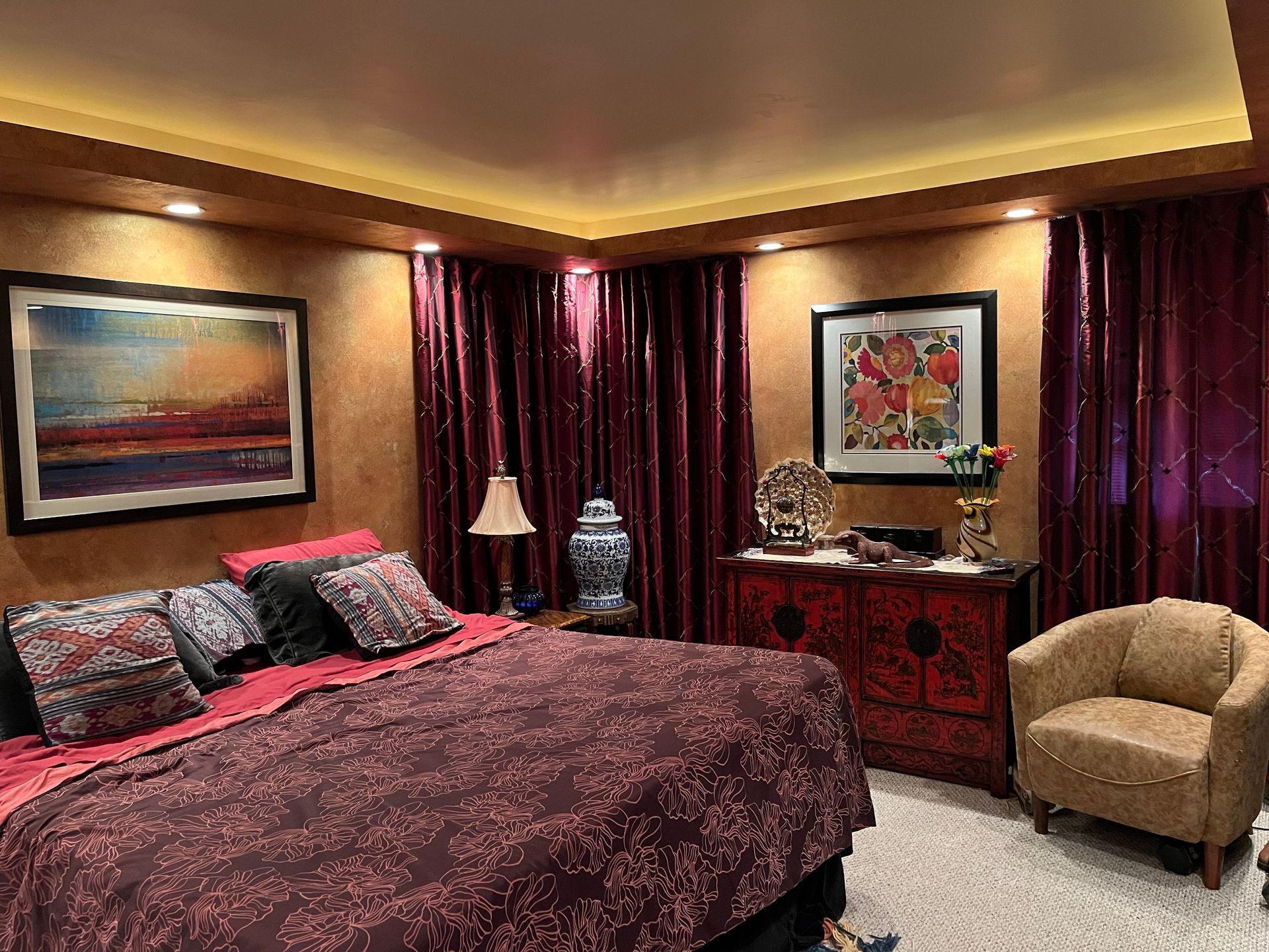 White kitchen island with dark gray countertop, wooden stools, and white cabinets.