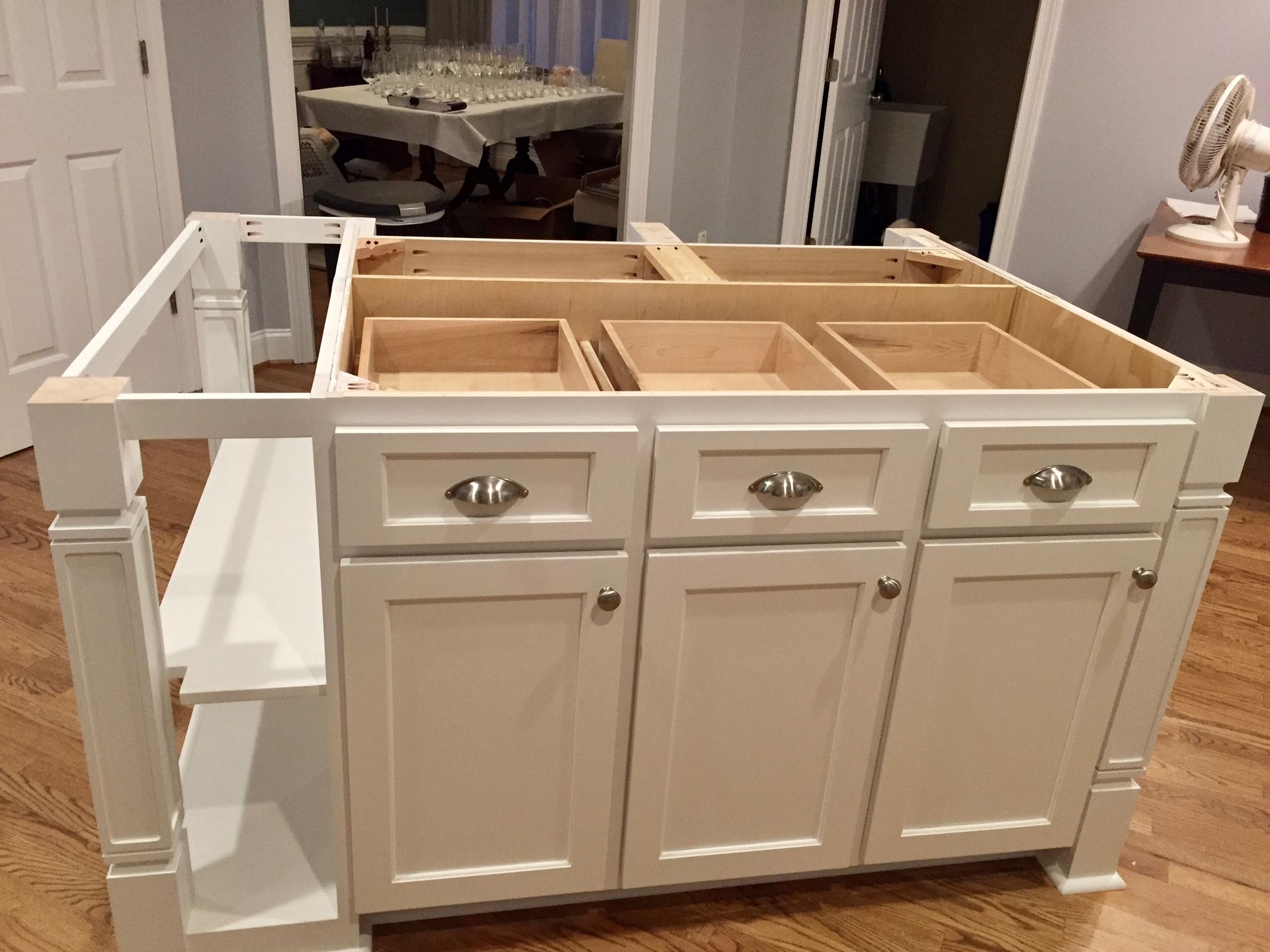 A room with a lot of white cabinets and a mirror.