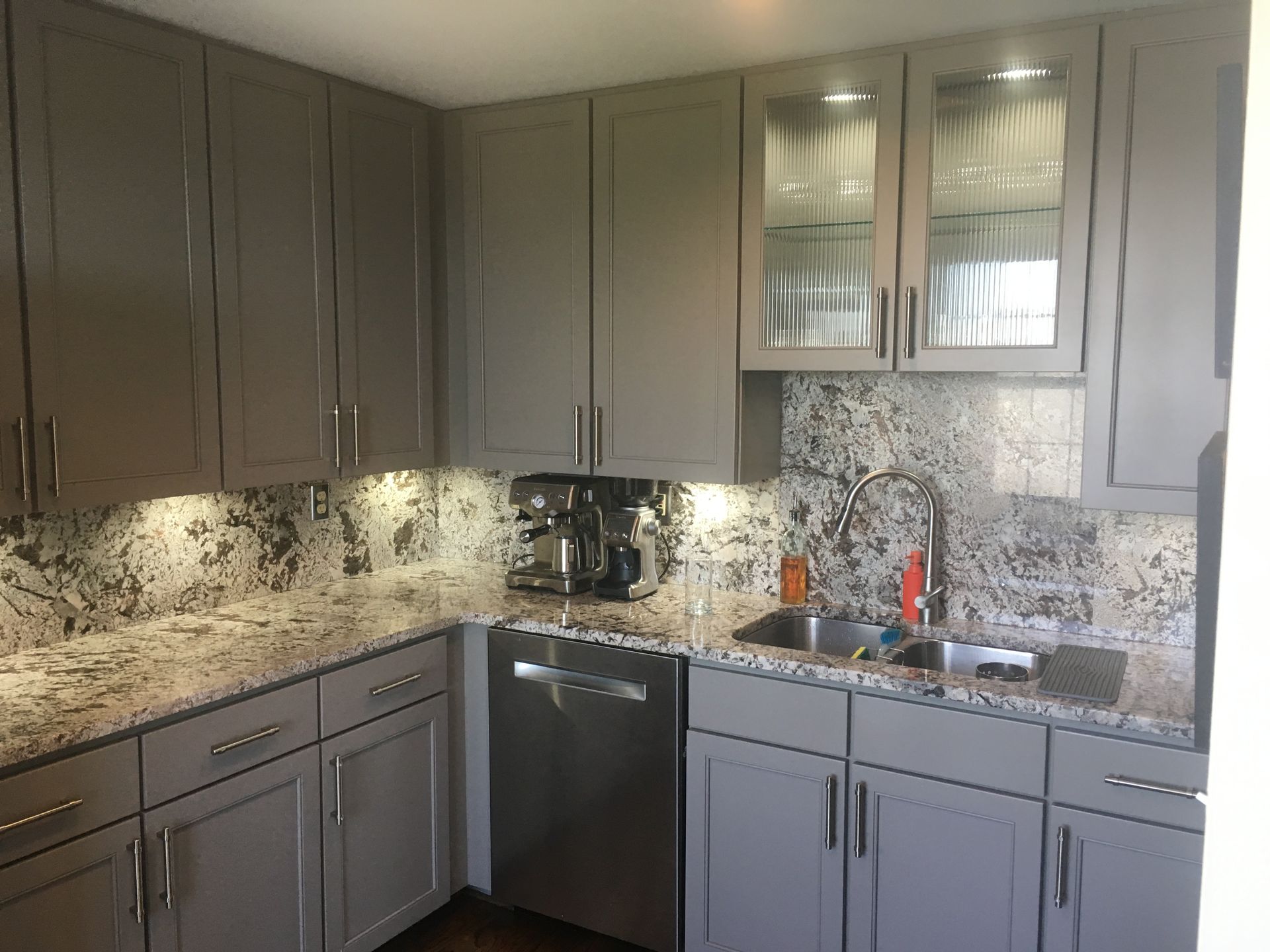 A room with a lot of white cabinets and a mirror.