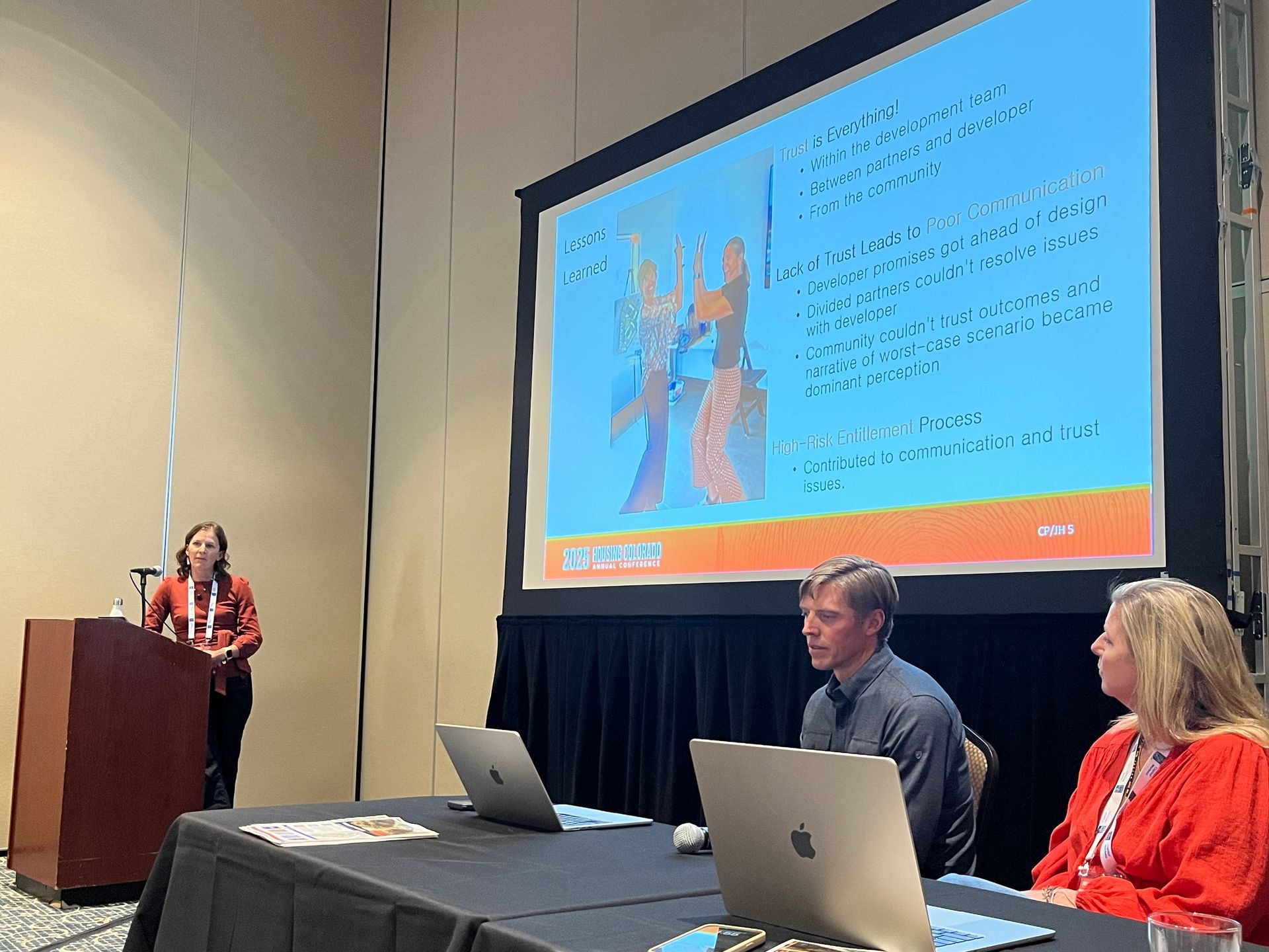 woman speaking with slides on large screen