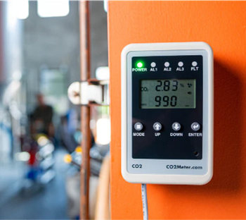 A device that says co2 on it is hanging on a wall