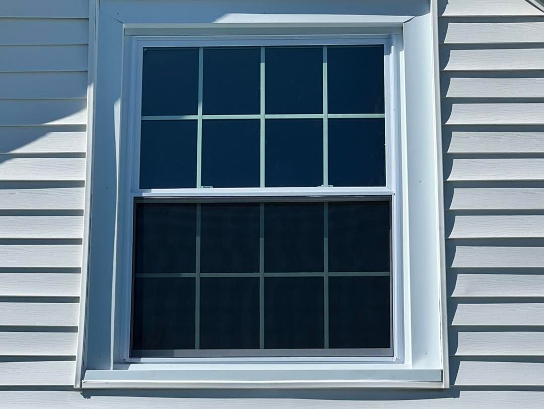 White window on a white clapboard wall. Window has eight panes in the top and bottom.