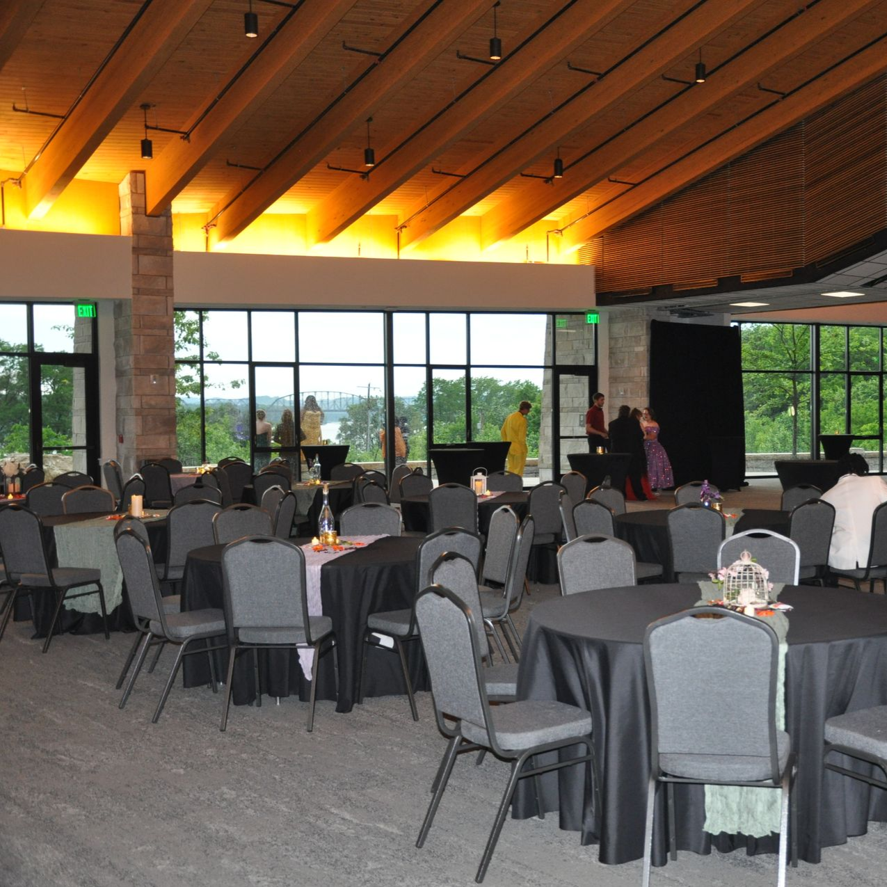 Meeting room with people seated around a long white table, looking at a screen. Large windows for a planning session.