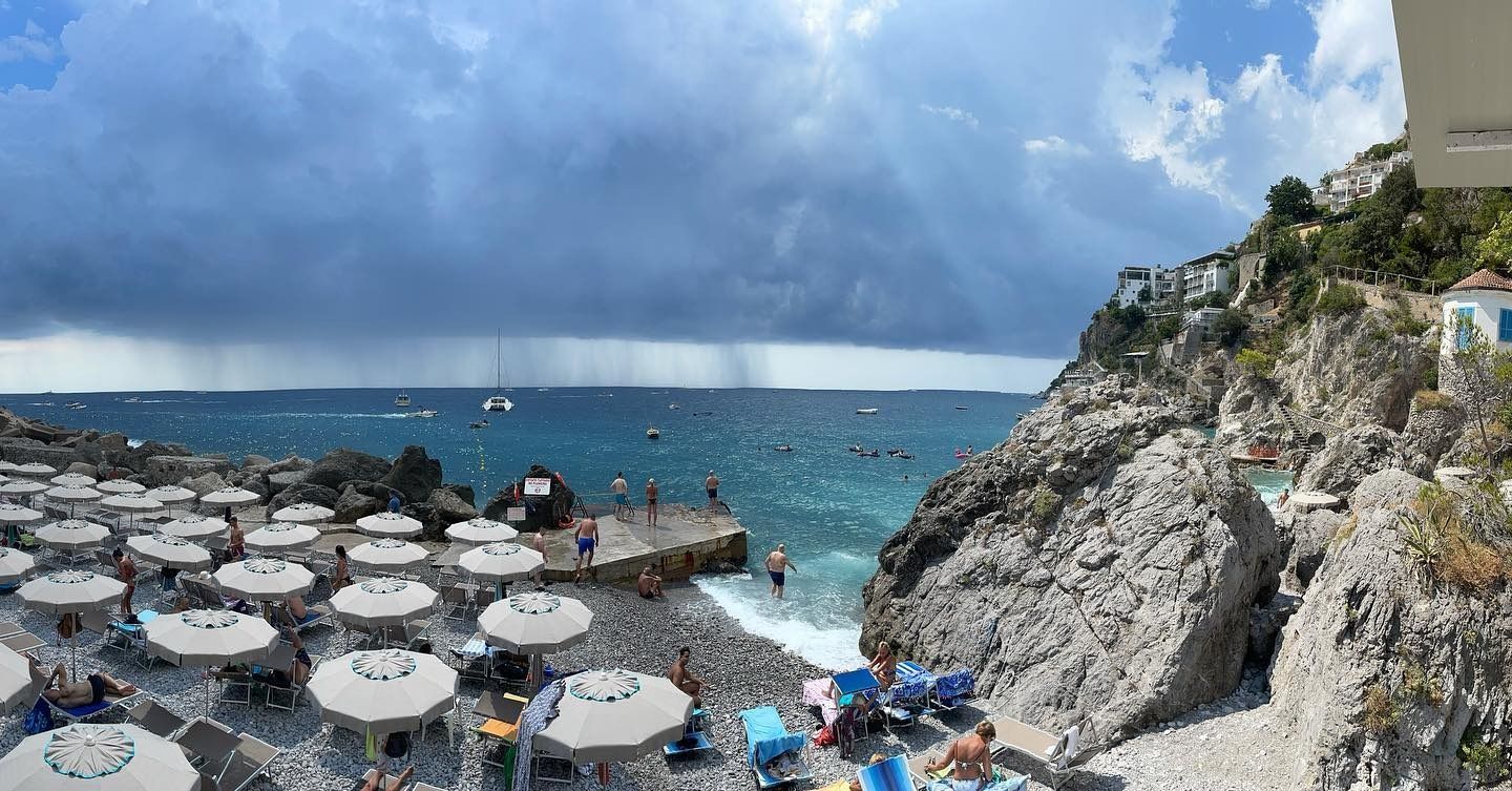 Una spiaggia con ombrelloni e sedie in una giornata nuvolosa