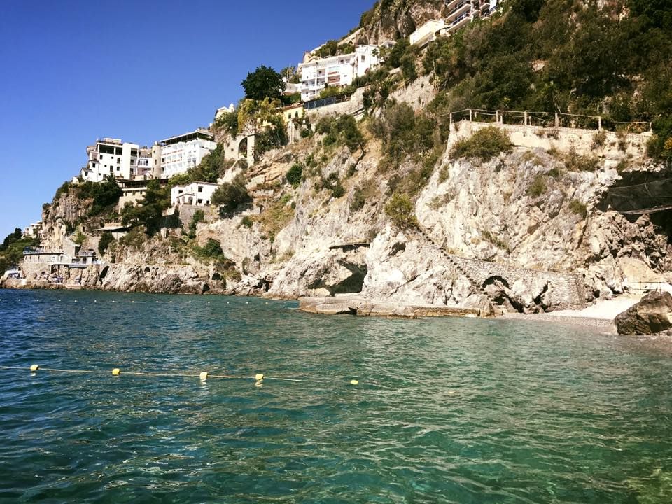 Una scogliera che domina uno specchio d'acqua con una città sullo sfondo