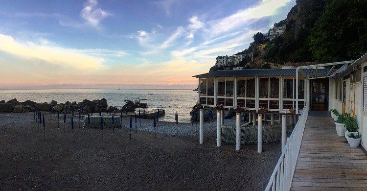 C'è un edificio sulla spiaggia con vista sull'oceano.