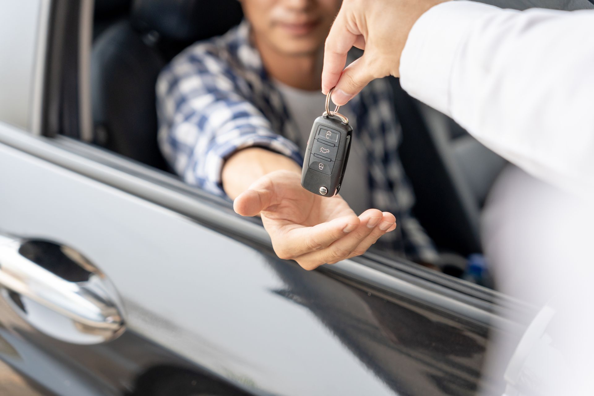 A rental agent hands over car keys.
