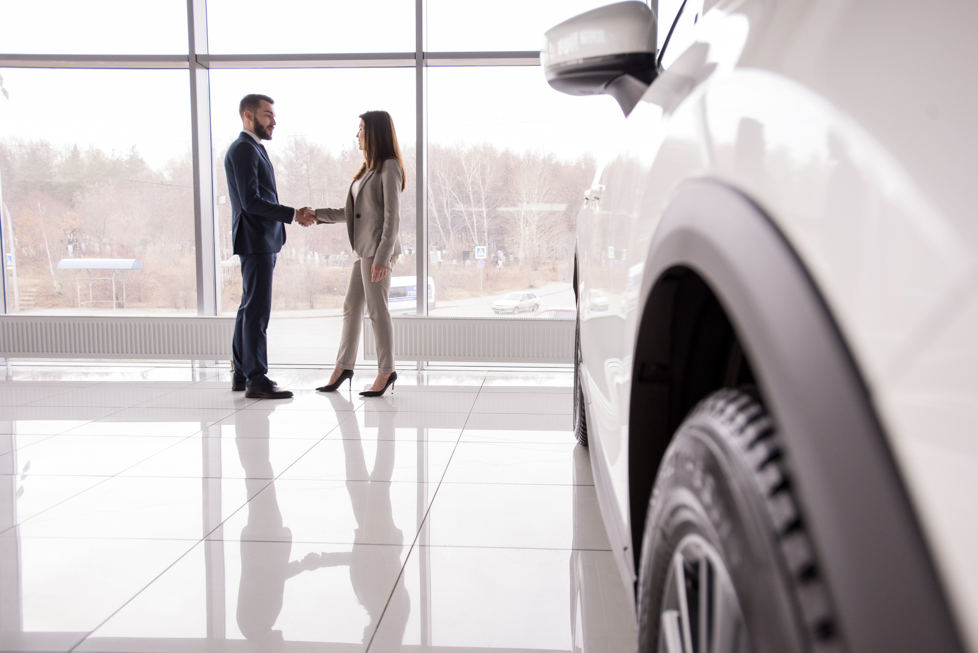 Man shaking hands with customer, showcasing excellent customer care in a car rental service.