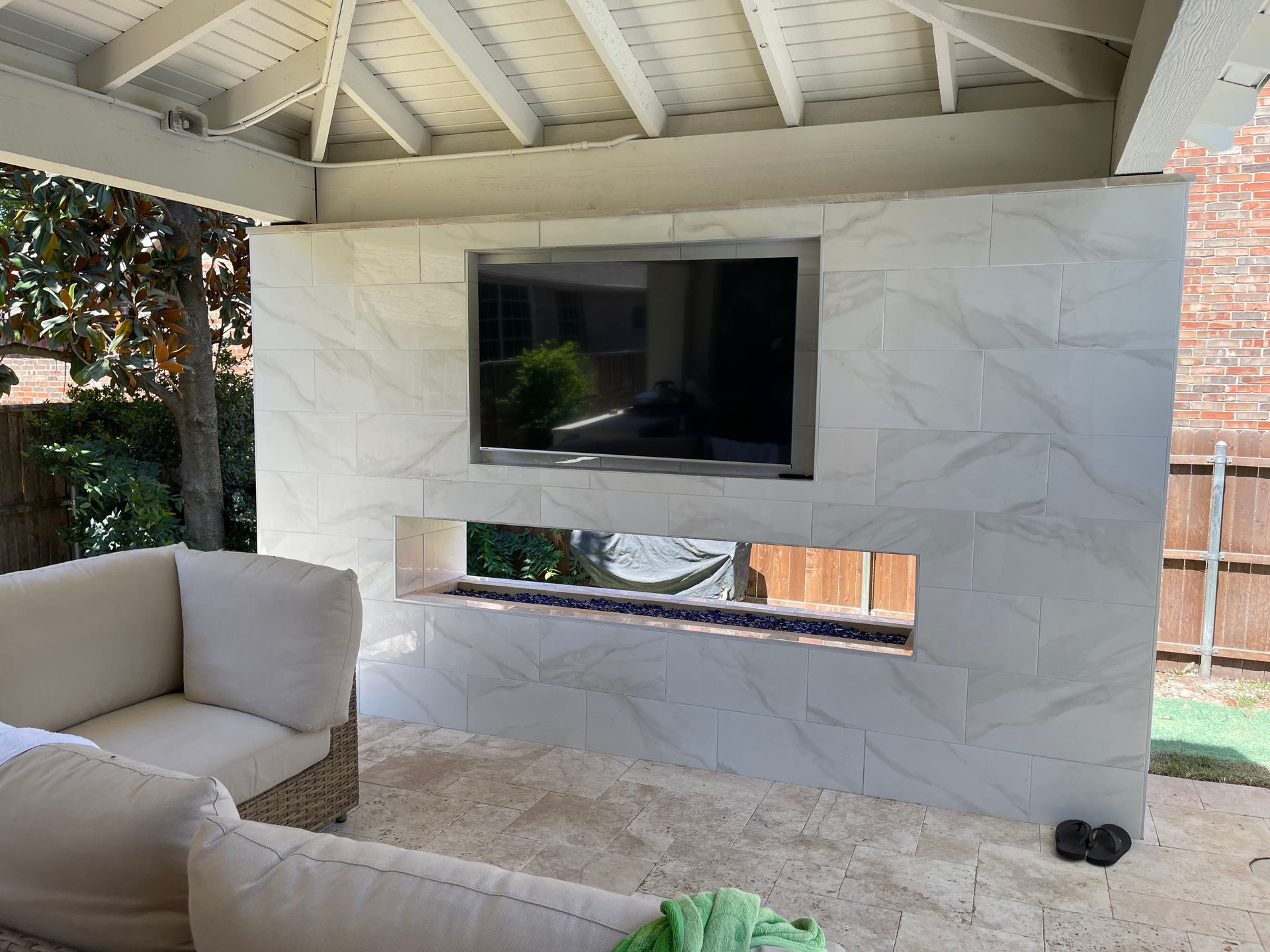 A luxurious outdoor patio featuring a wooden dining table and seating, merging seamlessly with a bright, modern living room.