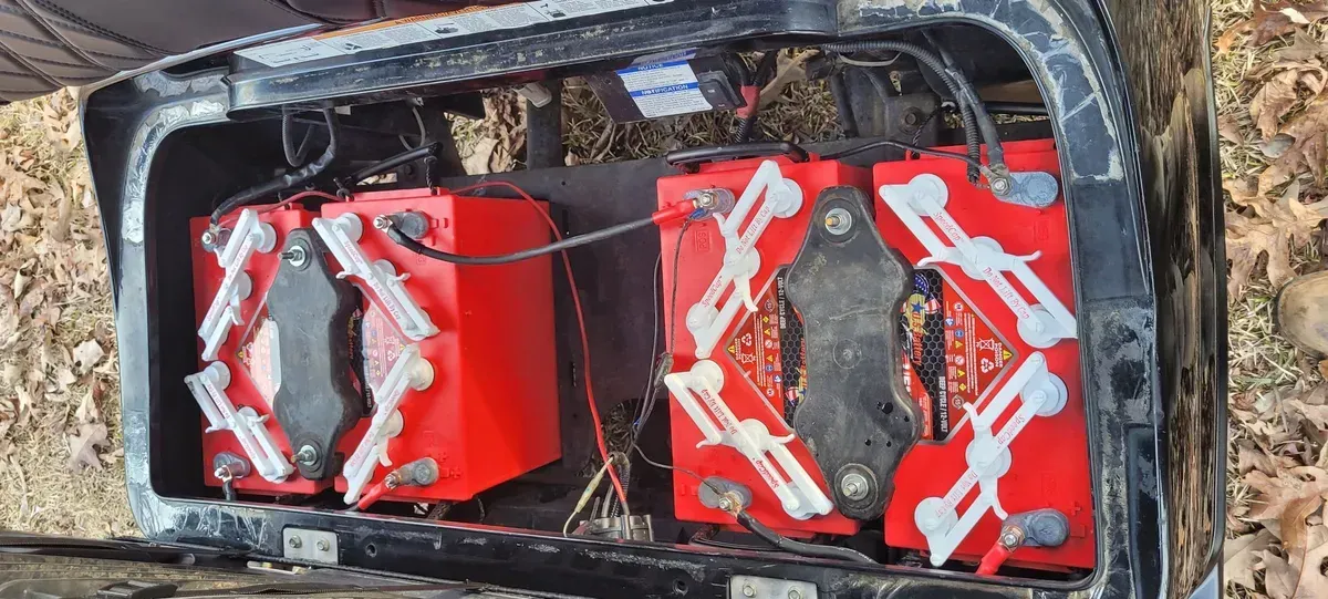A bunch of red batteries are sitting on top of a black box.