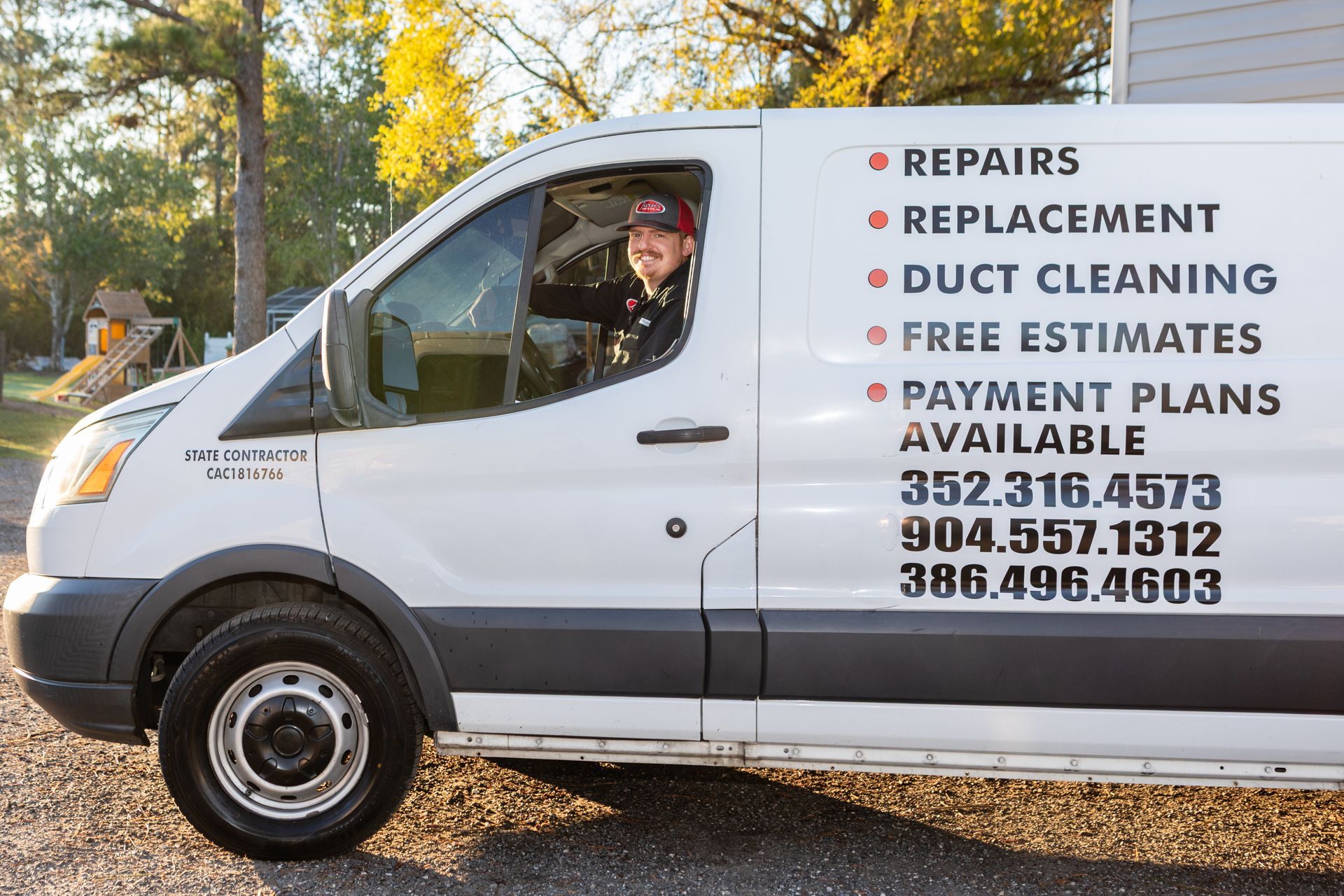 Two outdoor air conditioning units near a brick wall, sitting on concrete pads.