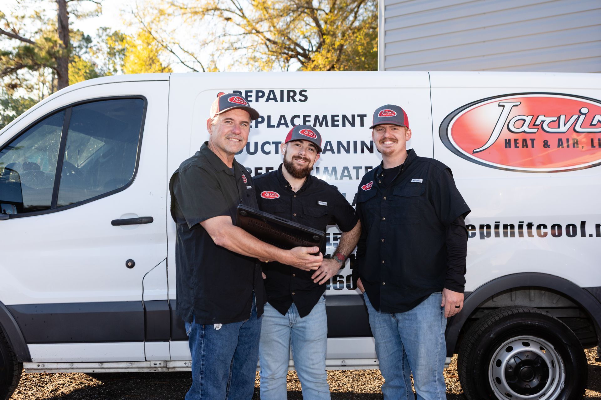 Two outdoor air conditioning units near a brick wall, sitting on concrete pads.