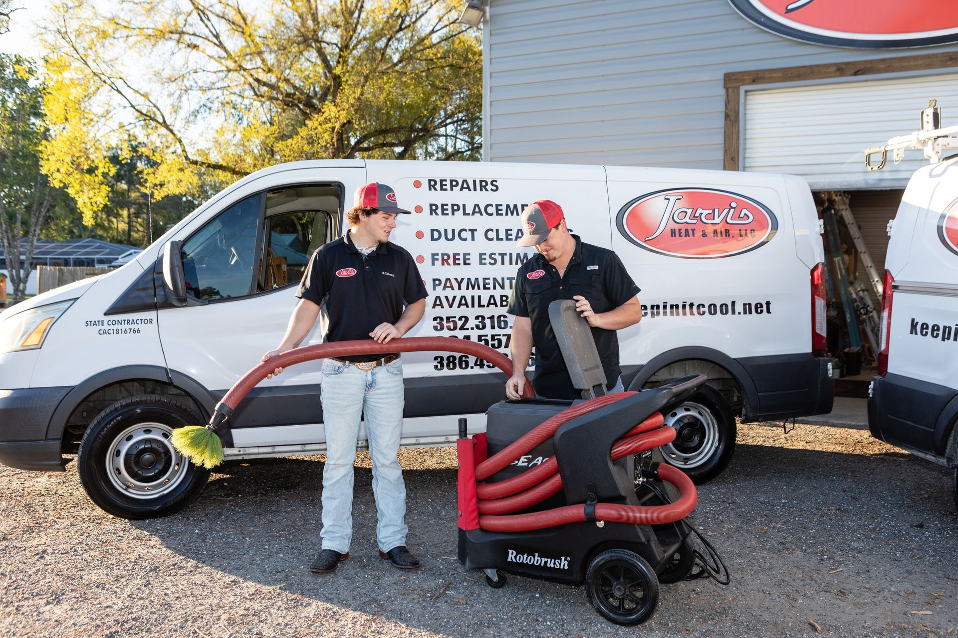 Woman examining an outdoor air conditioning unit on a balcony overlooking a coastal town.