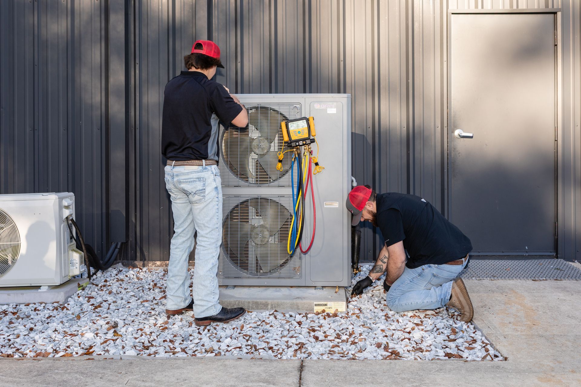Woman using a remote to control a wall-mounted air conditioner in a white room.