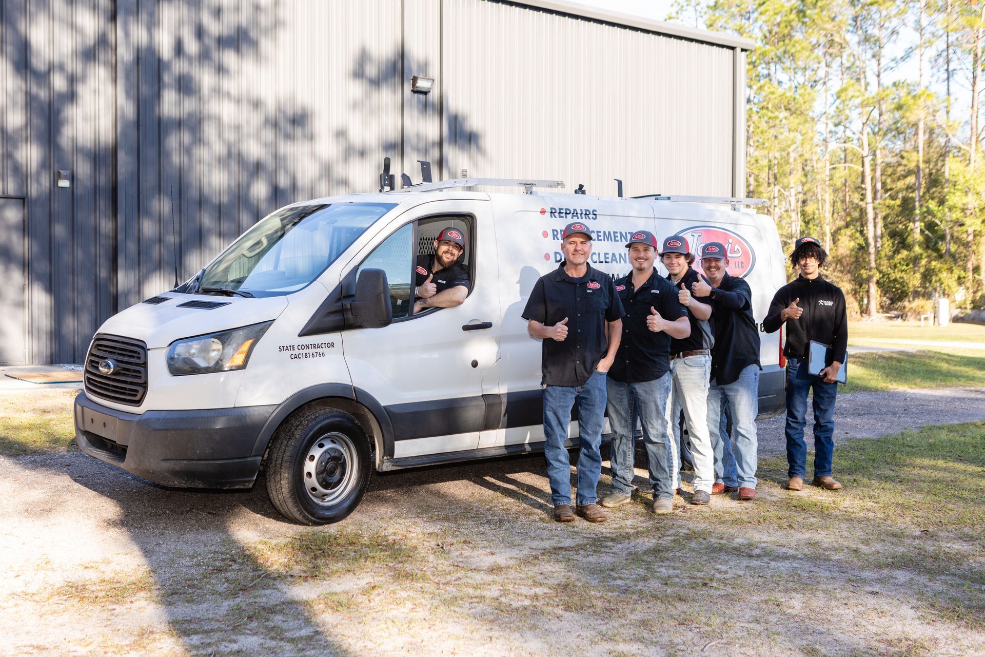 AC unit with gauges and colored hoses attached, outside building.