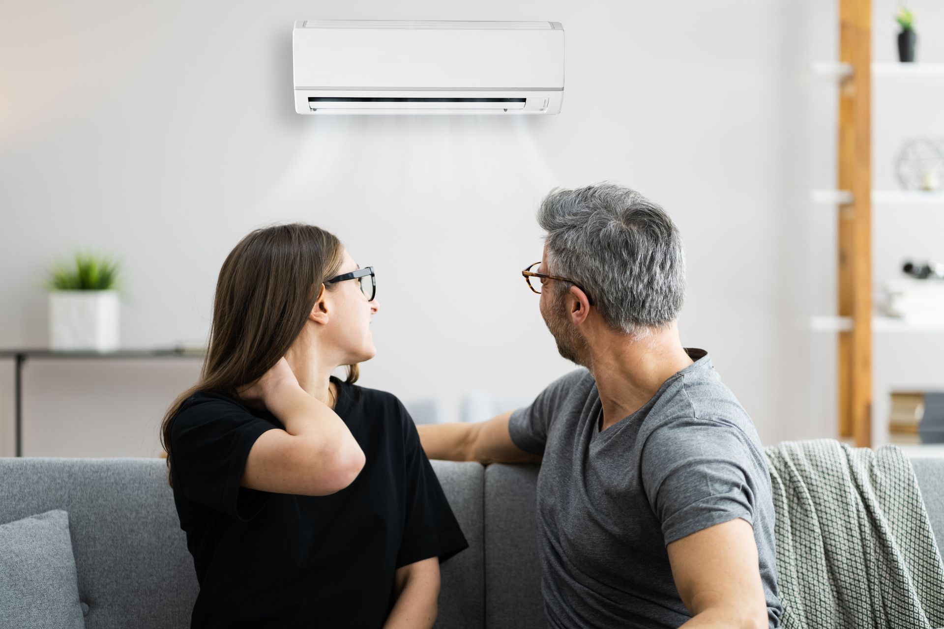 Homeowners looking at residential air conditioner during spring maintenance in Gainesville Florida.