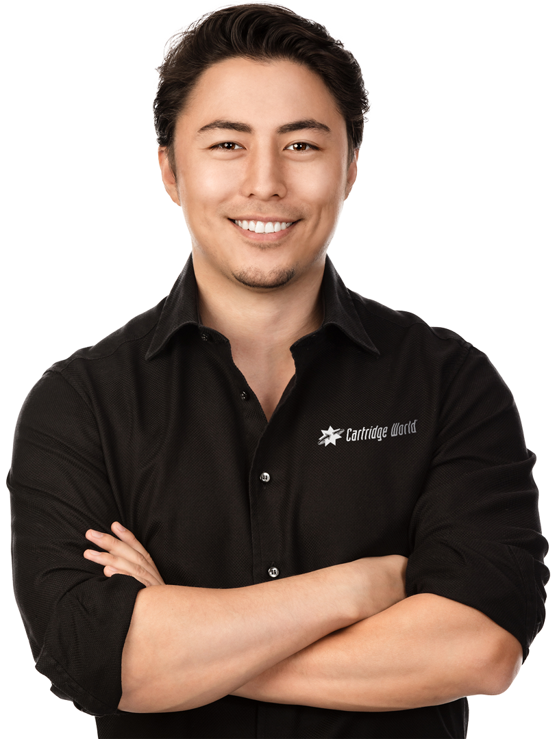 A man in a black shirt is smiling with his arms crossed
